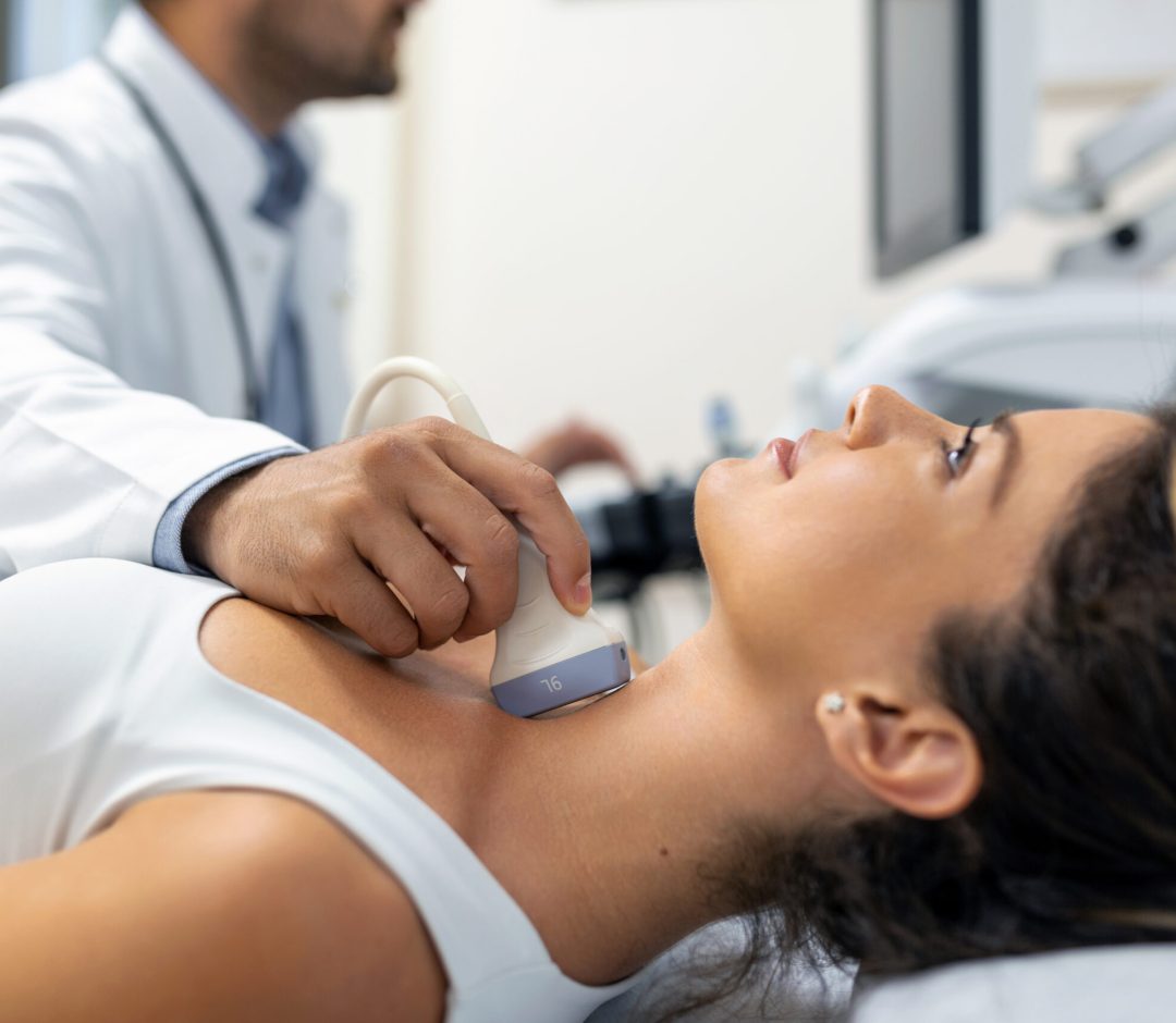 Close up shot of young woman getting her neck examined by doctor using ultrasound scanner at modern clinic