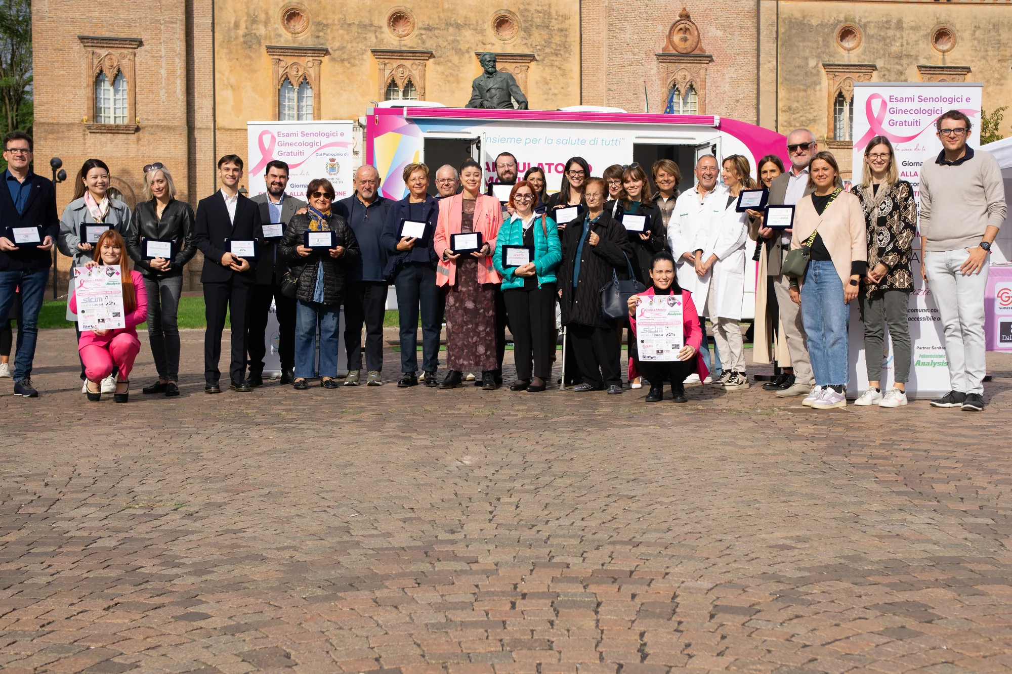Clinica Mobile a Busseto: foto di gruppo della Giornata della Prevenzione Rosa in Piazza Verdi