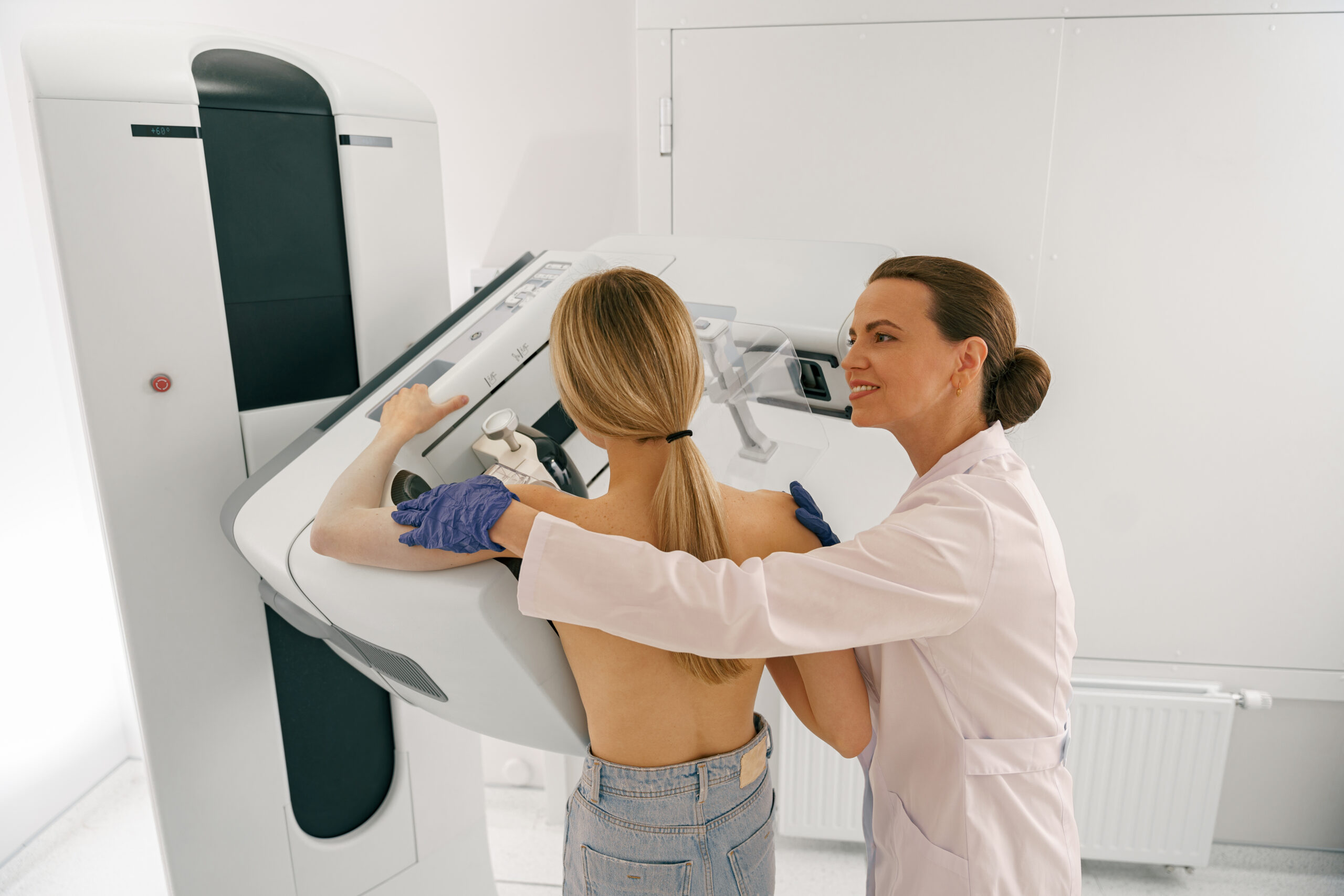 Professional radiologist doing mammogram x ray for young woman to check for breast cancer